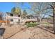 Expansive backyard with a wooden deck, stone landscaping, and mature trees, perfect for outdoor activities at 10858 E Harvard Dr, Aurora, CO 80014