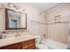 Bathroom with tan vanity, large mirror, and tiled tub-shower combination at 10858 E Harvard Dr, Aurora, CO 80014
