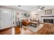 Cozy living room with brick fireplace, hardwood floors, and lots of natural light from a large picture window at 10858 E Harvard Dr, Aurora, CO 80014