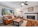 Inviting living room features a brick fireplace, wood floors, and a large window overlooking the front yard at 10858 E Harvard Dr, Aurora, CO 80014