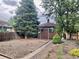 Spacious backyard featuring a wooden fence, grass, shed, and mature trees at 1881 S Lincoln St, Denver, CO 80210