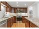 Traditional kitchen features stainless appliances, tile backsplash, granite counters, hardwood floors, and ample cabinet storage at 7255 S Vine St, Centennial, CO 80122