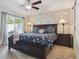 Bright main bedroom with a decorative accent wall, ceiling fan, sliding glass doors, and a plush queen bed at 7255 S Vine St, Centennial, CO 80122