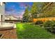 A lovely backyard featuring lush green grass, a wooden fence, and mature trees at 323 S Hoover Ave, Louisville, CO 80027