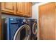 Efficient laundry room with modern, front-loading washer and dryer set and ample storage at 1040 Hemlock Way, Broomfield, CO 80020