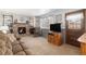 A cozy living room with a stone fireplace, plush carpeting, and ample natural light offers a comfortable retreat at 1040 Hemlock Way, Broomfield, CO 80020