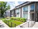 Modern townhome featuring landscaped front yard, patio, and walkway with metal railing at 47 Harrison, Denver, CO 80206