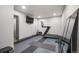 Home gym with mirrored wall, rubber flooring, treadmill and flatscreen TV for workouts at 47 Harrison, Denver, CO 80206