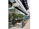 Modern restaurant exterior with glass facade and outdoor seating featuring colorful flower boxes and umbrellas at 47 Harrison, Denver, CO 80206