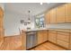 Charming kitchen with stainless steel dishwasher, light wood cabinets, and breakfast nook area at 31139 Tahoe Ct, Evergreen, CO 80439