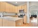 Bright kitchen with stainless steel microwave and oven, light wood cabinets, and tile countertops at 31139 Tahoe Ct, Evergreen, CO 80439