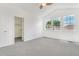 Bright, carpeted bedroom with three large windows for natural light, and a glimpse into the en-suite walk-in closet at 12317 W Gould Ave, Littleton, CO 80127