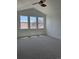Bright, carpeted bedroom featuring vaulted ceilings, neutral walls, a ceiling fan, and three large windows at 12317 W Gould Ave, Littleton, CO 80127