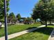 View of the community pool area with mature trees, shade pergolas, and lush landscaping at 12317 W Gould Ave, Littleton, CO 80127