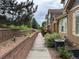 Landscaped walkway adjacent to the side of the townhome showing a brick retaining wall with white flowers at 12317 W Gould Ave, Littleton, CO 80127