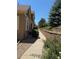 Exterior view of townhome featuring brick retaining wall and lush, well-maintained landscaping at 12317 W Gould Ave, Littleton, CO 80127