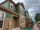 Two-story townhome featuring brown stucco and green siding, situated in a neighborhood under cloudy skies at 12317 W Gould Ave, Littleton, CO 80127