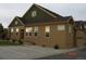 Tan home with green trim, showing a two-car garage and partial driveway at 12317 W Gould Ave, Littleton, CO 80127
