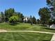Exterior view of community grounds with green grass, mature trees, and beautiful landscaping at 12317 W Gould Ave, Littleton, CO 80127