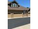 Townhome garage featuring a large door, exterior lighting, and blacktop driveway at 12317 W Gould Ave, Littleton, CO 80127