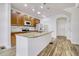 Well-lit kitchen features stainless appliances, wood cabinets, granite countertops, and an island with sink at 12317 W Gould Ave, Littleton, CO 80127