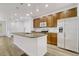 Kitchen with stainless appliances, wood cabinets, a white refrigerator, and a large island with a sink at 12317 W Gould Ave, Littleton, CO 80127