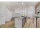 Open concept kitchen with island, stainless steel appliances, and wood cabinets leading to living area at 12317 W Gould Ave, Littleton, CO 80127