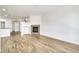 Spacious living room with fireplace and hardwood floors leading into adjacent kitchen area at 12317 W Gould Ave, Littleton, CO 80127