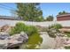 Serene backyard pond with rock features and lush greenery, creating a peaceful retreat at 6761 Harlan St, Arvada, CO 80003