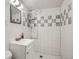 Clean bathroom with a white vanity, tiled shower, and well-organized storage shelves at 6761 Harlan St, Arvada, CO 80003