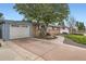 Home exterior featuring a driveway, garage, landscaped yard and a charming walkway to the front door at 6761 Harlan St, Arvada, CO 80003