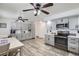 Spacious kitchen with gray cabinets, stainless steel appliances, and hardwood flooring, ideal for cooking and dining at 6761 Harlan St, Arvada, CO 80003