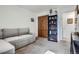 Cozy living room featuring a gray sofa, stylish bookcase and closet, perfect for relaxation and storage at 6761 Harlan St, Arvada, CO 80003