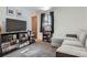 Comfortable living room with a gray couch, TV, and bookshelves, creating a cozy and functional space at 6761 Harlan St, Arvada, CO 80003