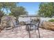 Charming outdoor patio with patterned tile, cozy seating around a fire pit, and beautiful landscaping at 6761 Harlan St, Arvada, CO 80003