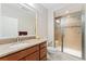 Full bath featuring a glass shower stall, vanity and a decorative mirror at 8851 E 33Rd Ave, Denver, CO 80238