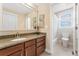 Well-lit bathroom featuring granite counters and a tiled shower, adjoining a view of the commode at 8851 E 33Rd Ave, Denver, CO 80238