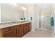 Elegant bathroom boasts double sinks, granite countertops, a large mirror, and a glass-enclosed shower at 8851 E 33Rd Ave, Denver, CO 80238