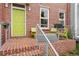 Cozy front porch featuring brick steps and seating area with bright green chairs at 8851 E 33Rd Ave, Denver, CO 80238
