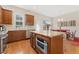 Bright kitchen features wood cabinets, stainless appliances, granite counters, and an island with built-in oven at 8851 E 33Rd Ave, Denver, CO 80238