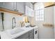 Compact kitchen with stainless steel appliances, gray cabinets, and bright natural light from a window at 1024 E 14Th Ave # 9, Denver, CO 80218