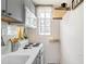 Efficient kitchen with white appliances, gray cabinets, and natural light from the window at 1024 E 14Th Ave # 9, Denver, CO 80218