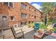 Cozy brick building patio area with an outdoor grill, comfortable seating, and mature trees at 1024 E 14Th Ave # 9, Denver, CO 80218