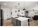 Open kitchen with an island, stainless steel appliances, barstool seating, and a view to living area at 9157 Rio Lado St, Littleton, CO 80125