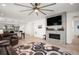Open-concept living room with modern fireplace, TV, and a view of the dining area and kitchen at 9157 Rio Lado St, Littleton, CO 80125
