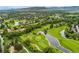 Scenic aerial view features a well-maintained golf course surrounded by ponds, trees, and residential areas at 15061 W 70Th Ave, Arvada, CO 80007