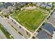 An aerial view of a large green lawn surrounded by homes, a parking lot, and manicured landscaping at 15061 W 70Th Ave, Arvada, CO 80007