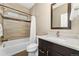 Well-lit bathroom features a bathtub with tiled walls and shower, vanity, and a clean, modern design at 15061 W 70Th Ave, Arvada, CO 80007