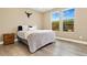 Bright bedroom with two large windows offering scenic views, complemented by wood floors and neutral decor at 15061 W 70Th Ave, Arvada, CO 80007