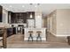Modern kitchen features stainless steel appliances, dark cabinets, and a cozy breakfast bar with pendant lighting at 15061 W 70Th Ave, Arvada, CO 80007